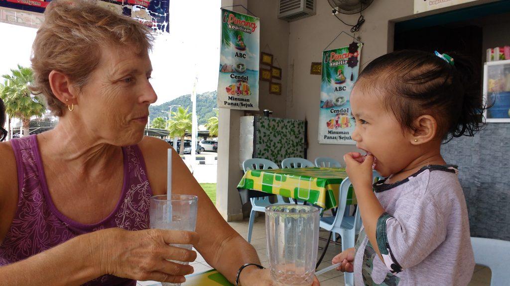 At a boatyard café in Malaysia, Jan enjoys lunch with a new little friend.